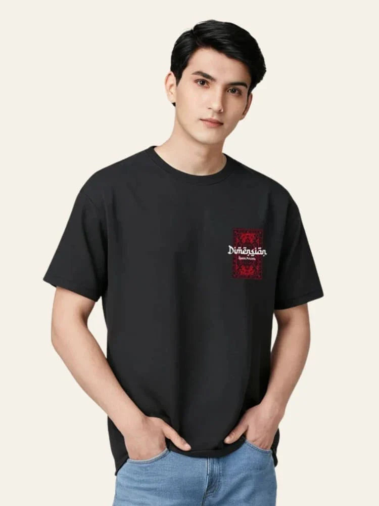 Person wearing a black t-shirt with a red logo on a plain background