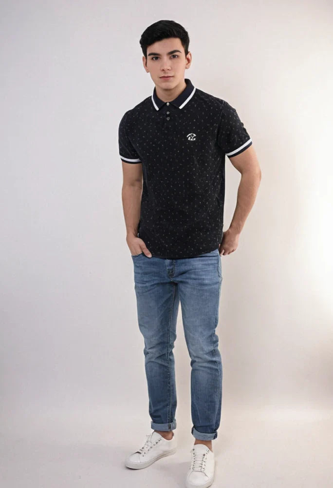 Man wearing a black patterned polo shirt, blue jeans, and white sneakers on a white background Black Dotted Regular Fit Men’s Polo T-Shirt Royal Outfits