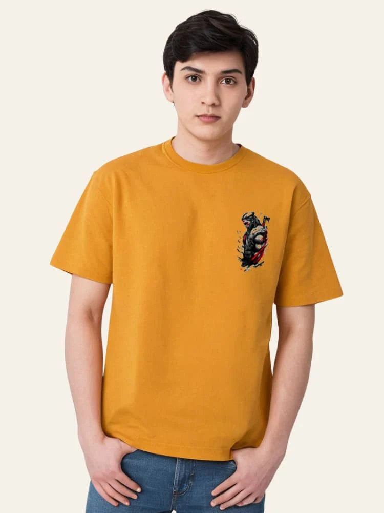 Person wearing a mustard yellow t-shirt with a graphic design on a plain background