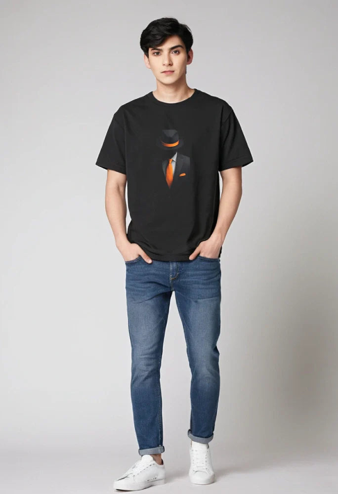 Person wearing a black t-shirt with a graphic design of a person in a suit and tie, paired with blue jeans and white sneakers on a plain background.