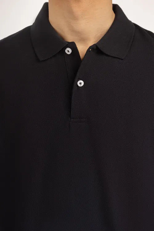 Close-up of a black polo shirt with a plain background