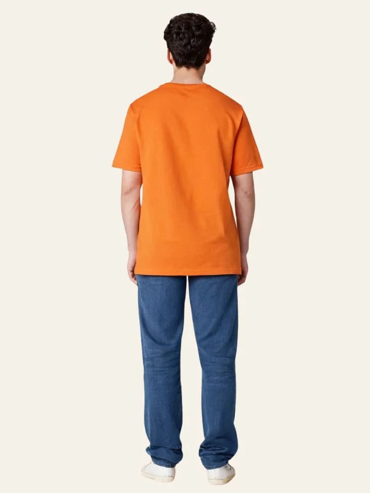 Person wearing an orange t-shirt and blue pants on a white background